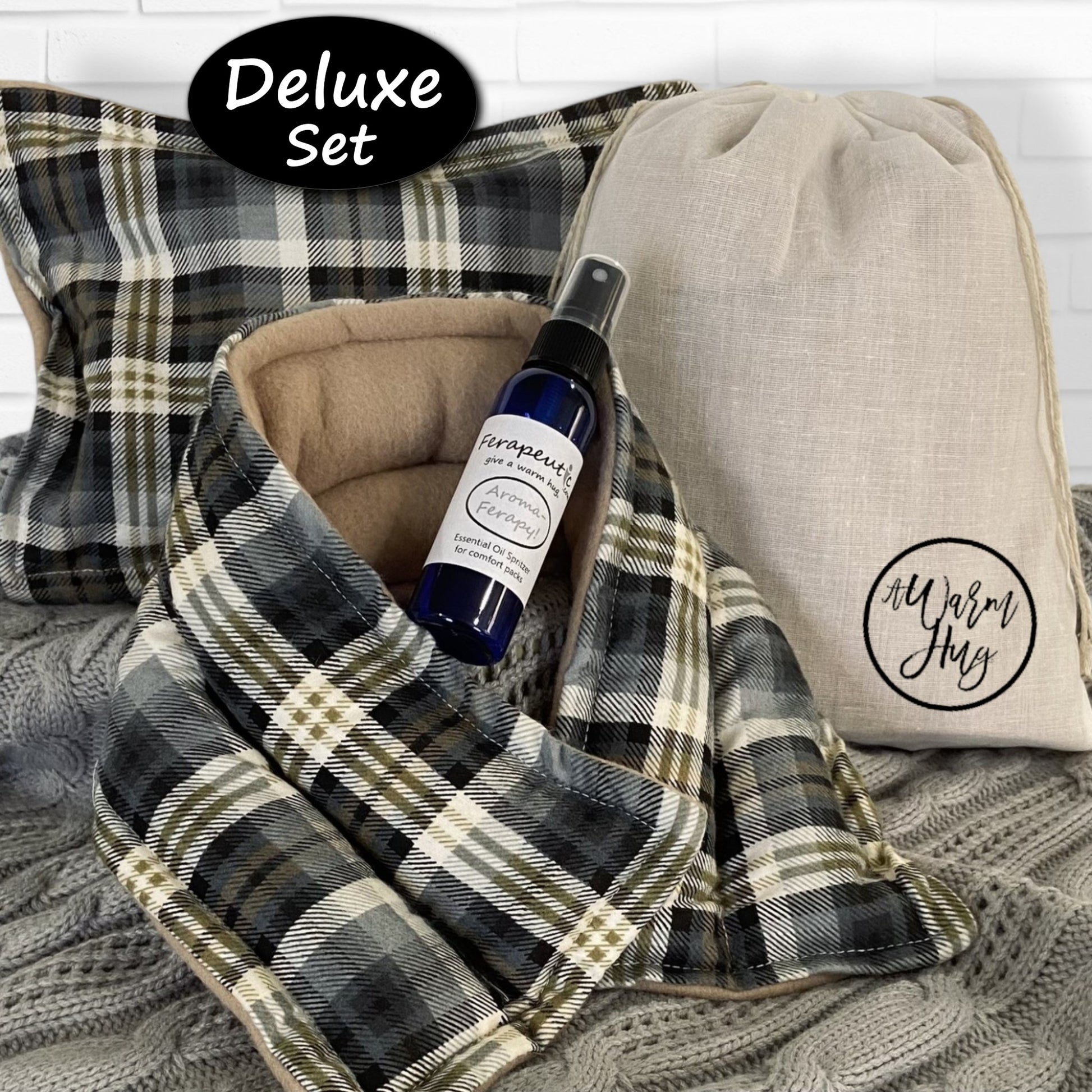 Plaid microwave hear pack with bottle of essential oil and pillow labeled 'A Warm Hug' on a textured surface.