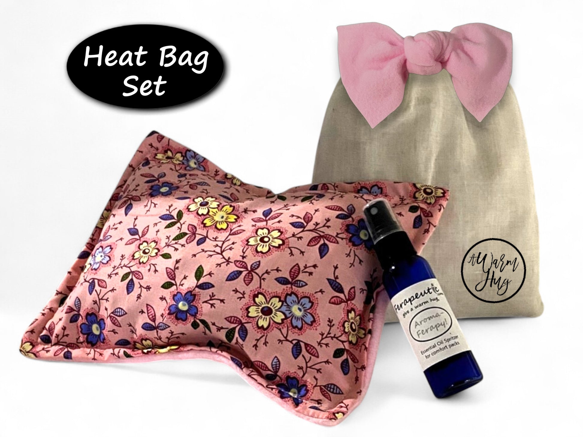 Heat bag set with floral design, bottle of essential oil, and branded gift bag with bow on a white background
