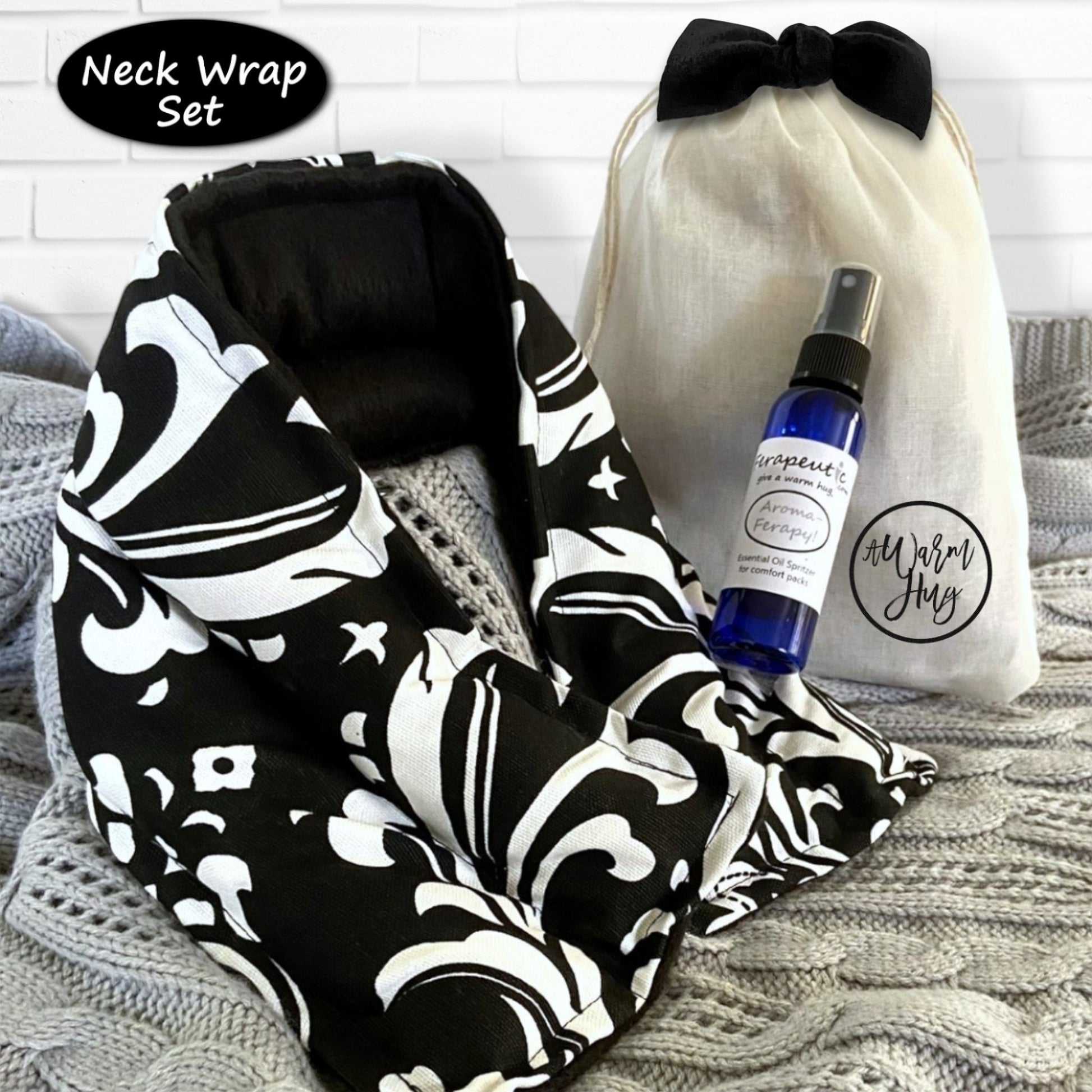 Neck wrap set with black and white pattern, spray bottle, and gift bag on a textured surface.