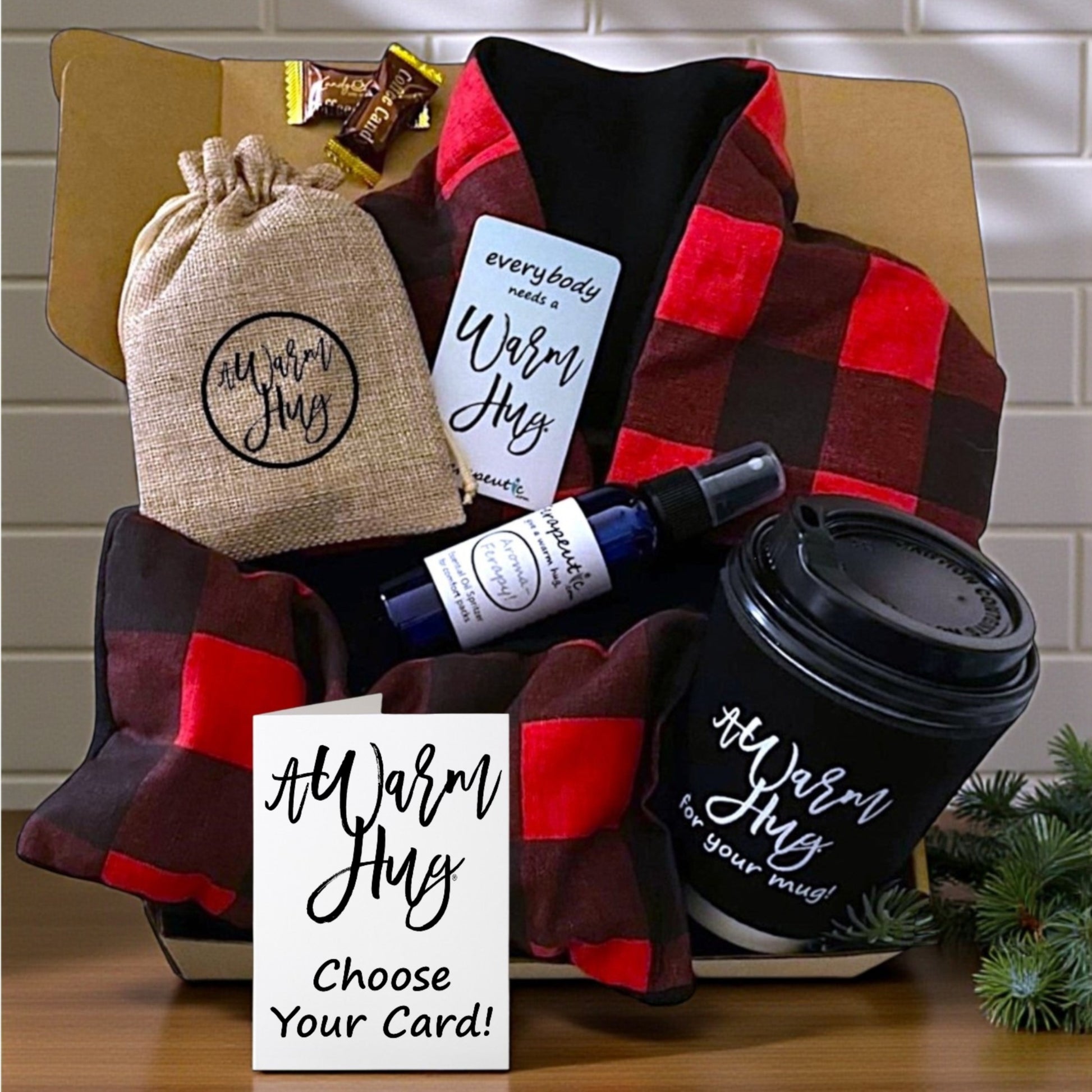 Gift set with plaid personal heating pads, coffee cup, and 'Warm Hug' items on a wooden surface.
