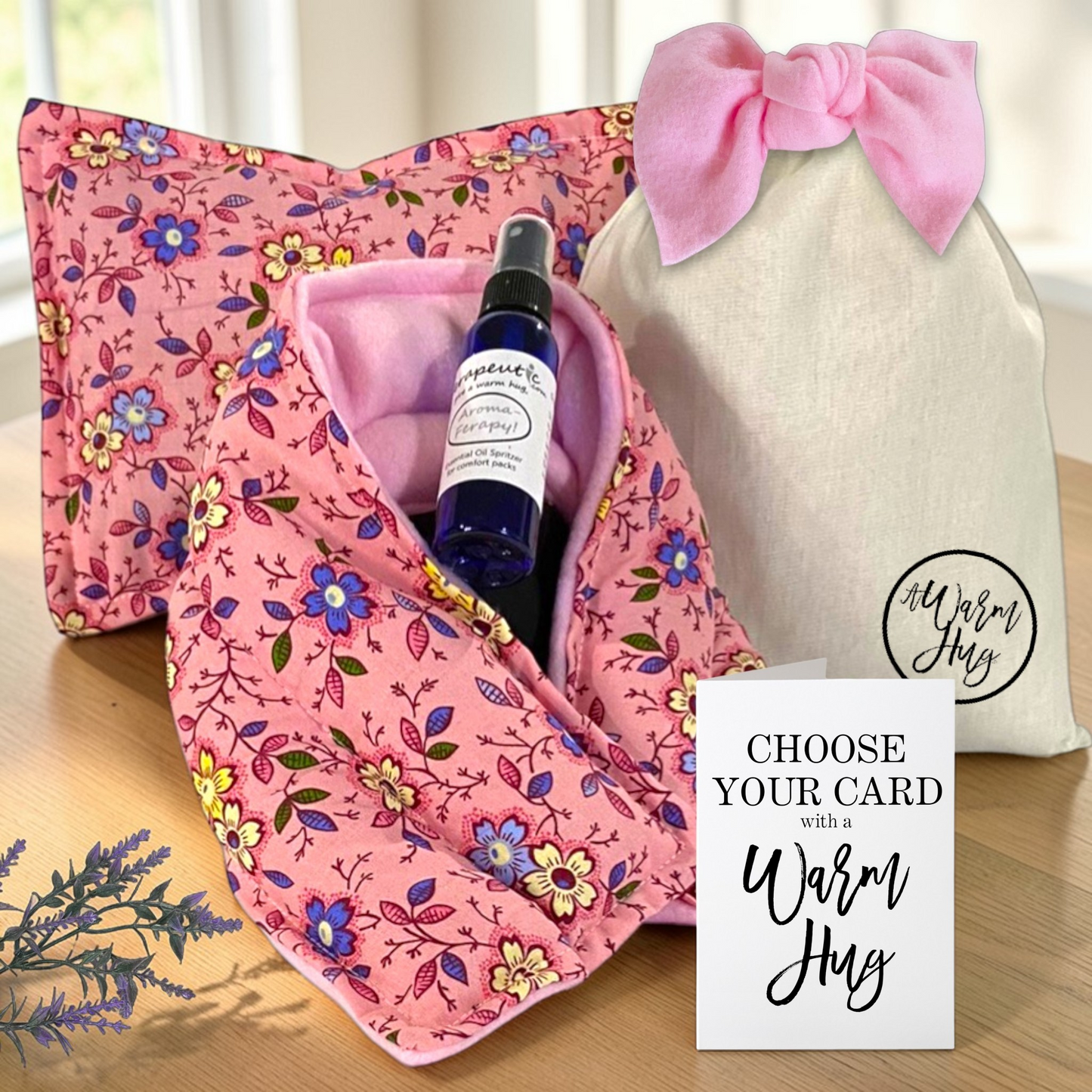 Warm Hug Gift Set in Pink floral fabric consisting of microwavable neck wrap and heat bag; aromatherapy lavender essential oil spray and warm hug greeting card