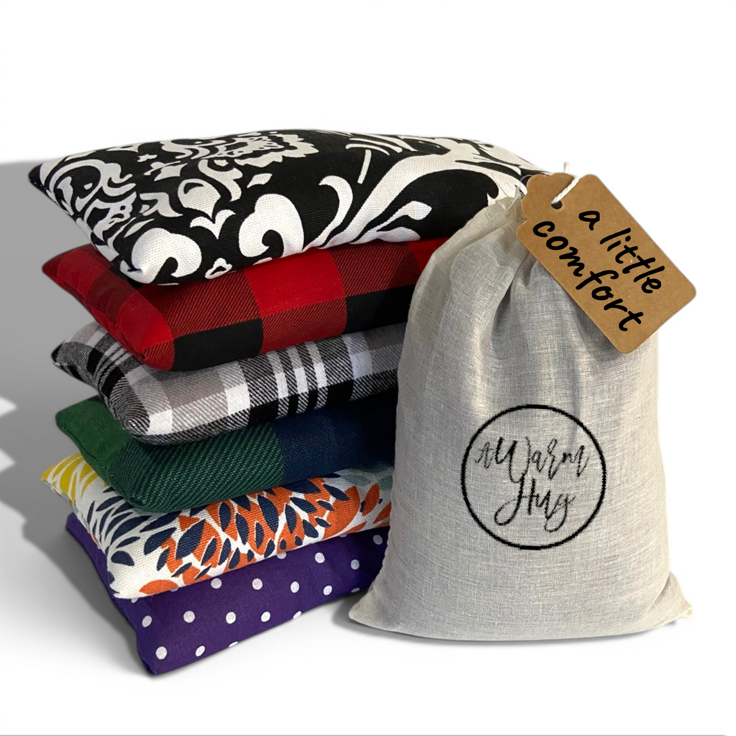 Cozy collection of microwavable heat pads with warm hug gift bag and gift tag that reads 'a little comfort'