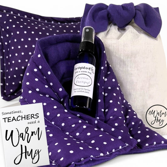 Microwavable heat pack gift set with a teacher appreciation card that reads 'sometimes teachers need a warm hug.' Includes a natural flax and rice heating pad, reusable cotton gift bag, and lavender essential oil spritzer