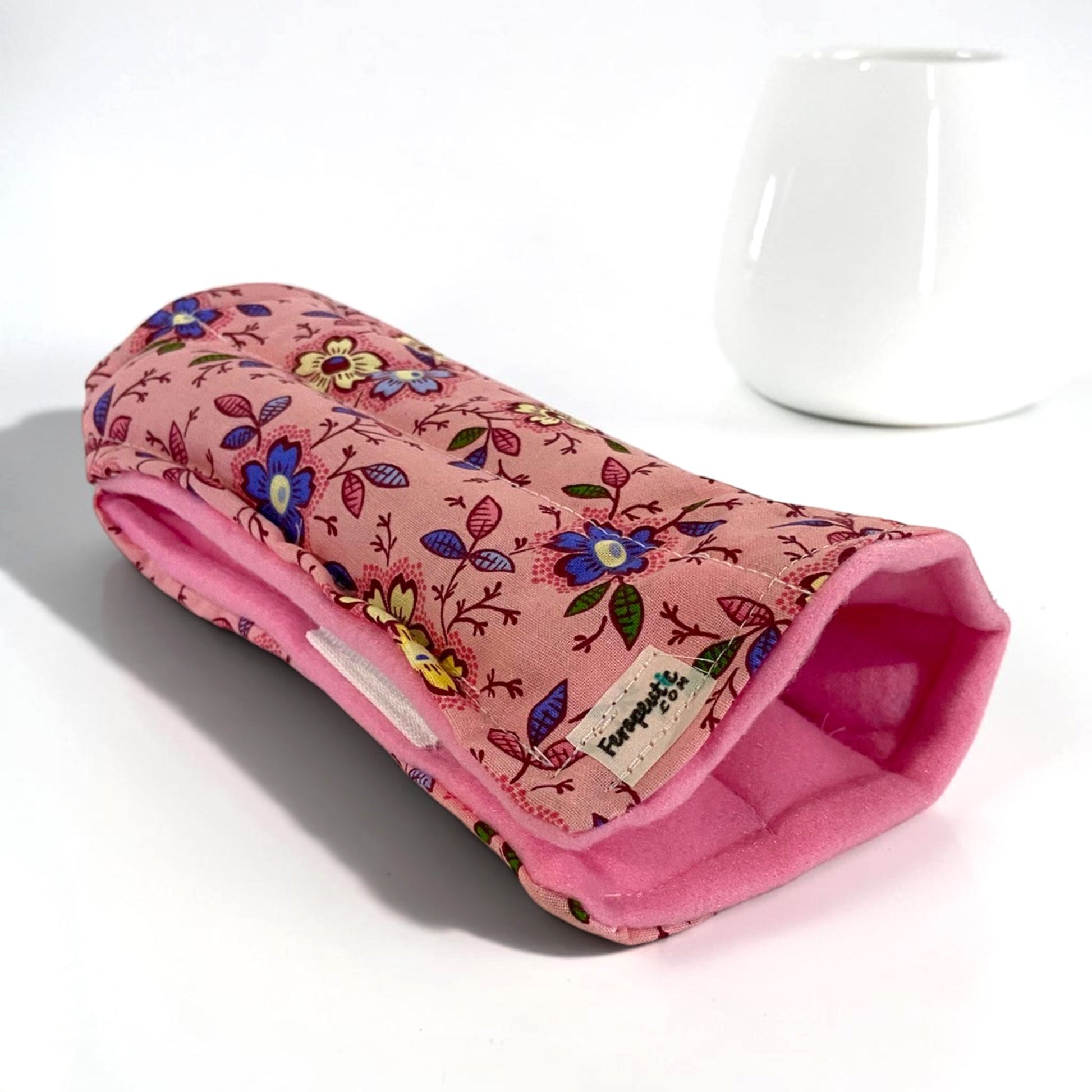 A wrist heating pad or cold wrap for right or left hand in pink flowered fabric.